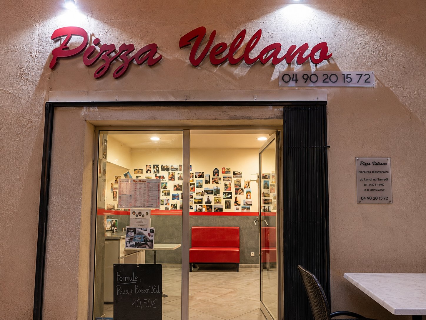 Façade de nuit de Pizza Vellano, avec son enseigne lumineuse